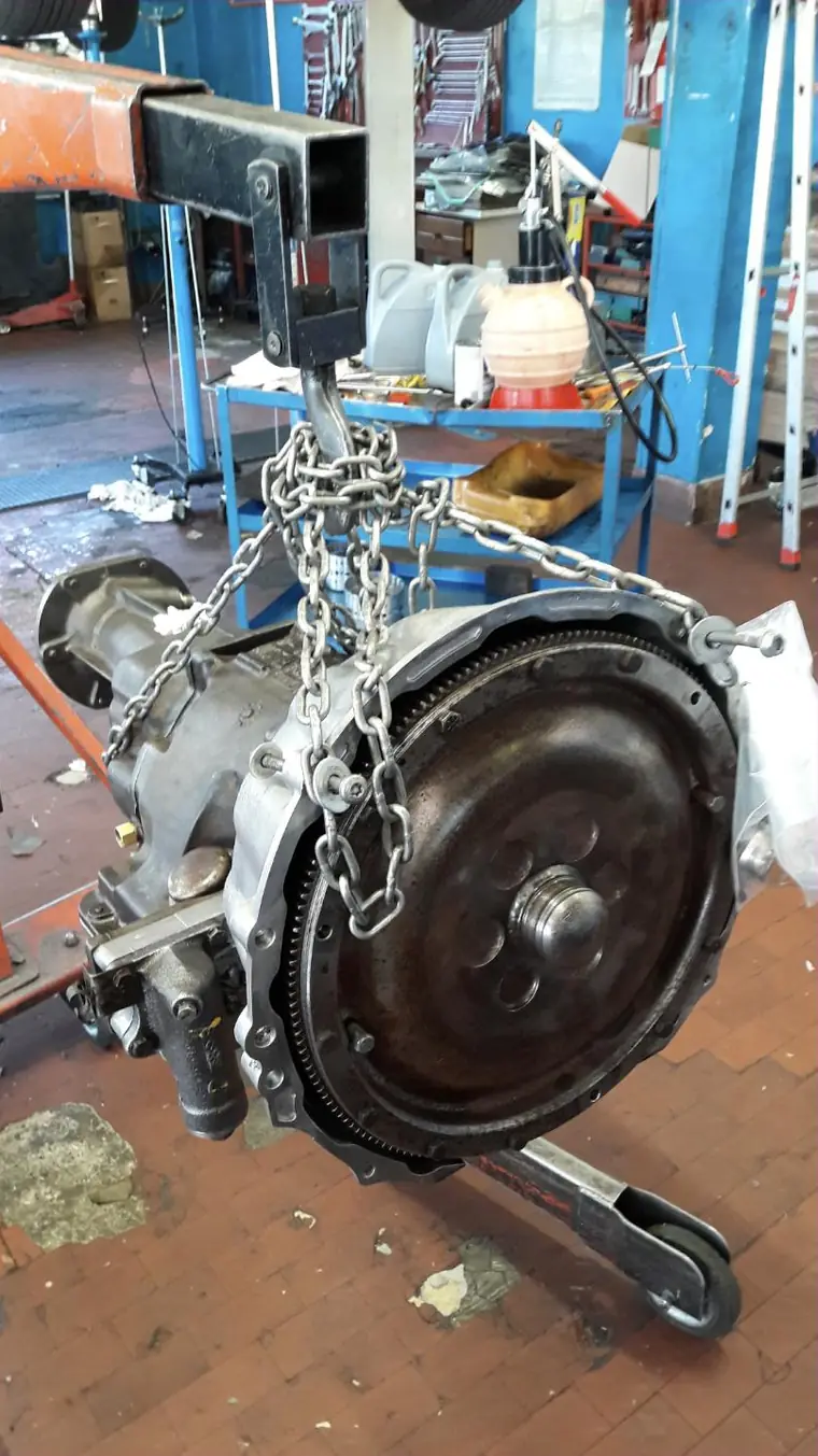 Cambio automatico sollevato con paranco a catena all'interno dell'officina